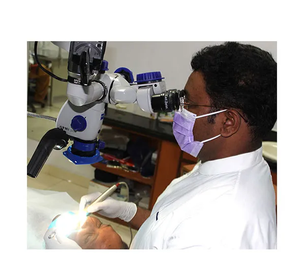 Dr. Vinod Kumar treating a patient under the operating microscope